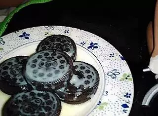 She playfully teases her pussy with an oreo in this fetish scene.