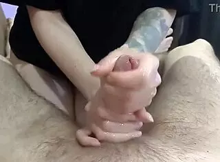 Masseuse giving an oily handjob in the bedroom