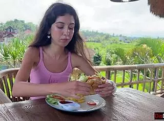 cute girl enjoys burger in public cafe