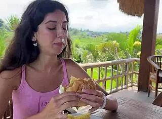 cute girl enjoys burger in public cafe