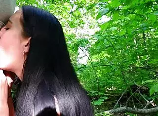 Young black-haired girlfriend gives sloppy handjob and swallows cum in forest nature setting