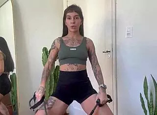 hey, check out this inked girl doing a rubber band workout for warm up and strength in sfw yoga fitness