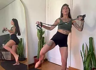 hey, check out this inked girl doing a rubber band workout for warm up and strength in sfw yoga fitness