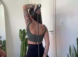 hey, check out this inked girl doing a rubber band workout for warm up and strength in sfw yoga fitness