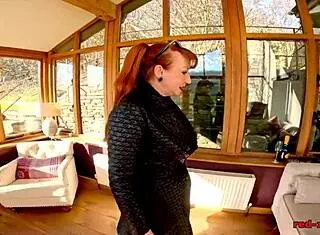 Busty British redhead in boots and stockings fingers her wet pussy.