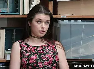 Confused teen shoplifter bent over by security guard.