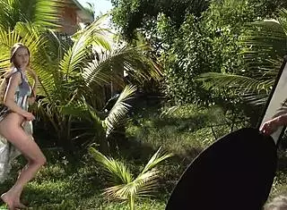 The sexy teen 18+ in a hat and dress poses naked outdoors with hairless body