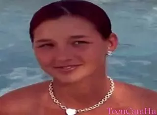 A teen model teases with big tits in bikini by the pool