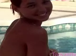 A teen model teases with big tits in bikini by the pool