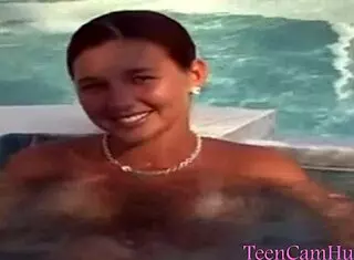 A teen model teases with big tits in bikini by the pool